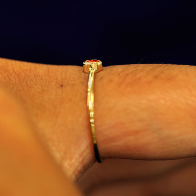 Side view of a solid gold Fire Opal Ring on a model's finger
