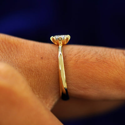 Side view of a Diamond Petal Ring on a model's finger