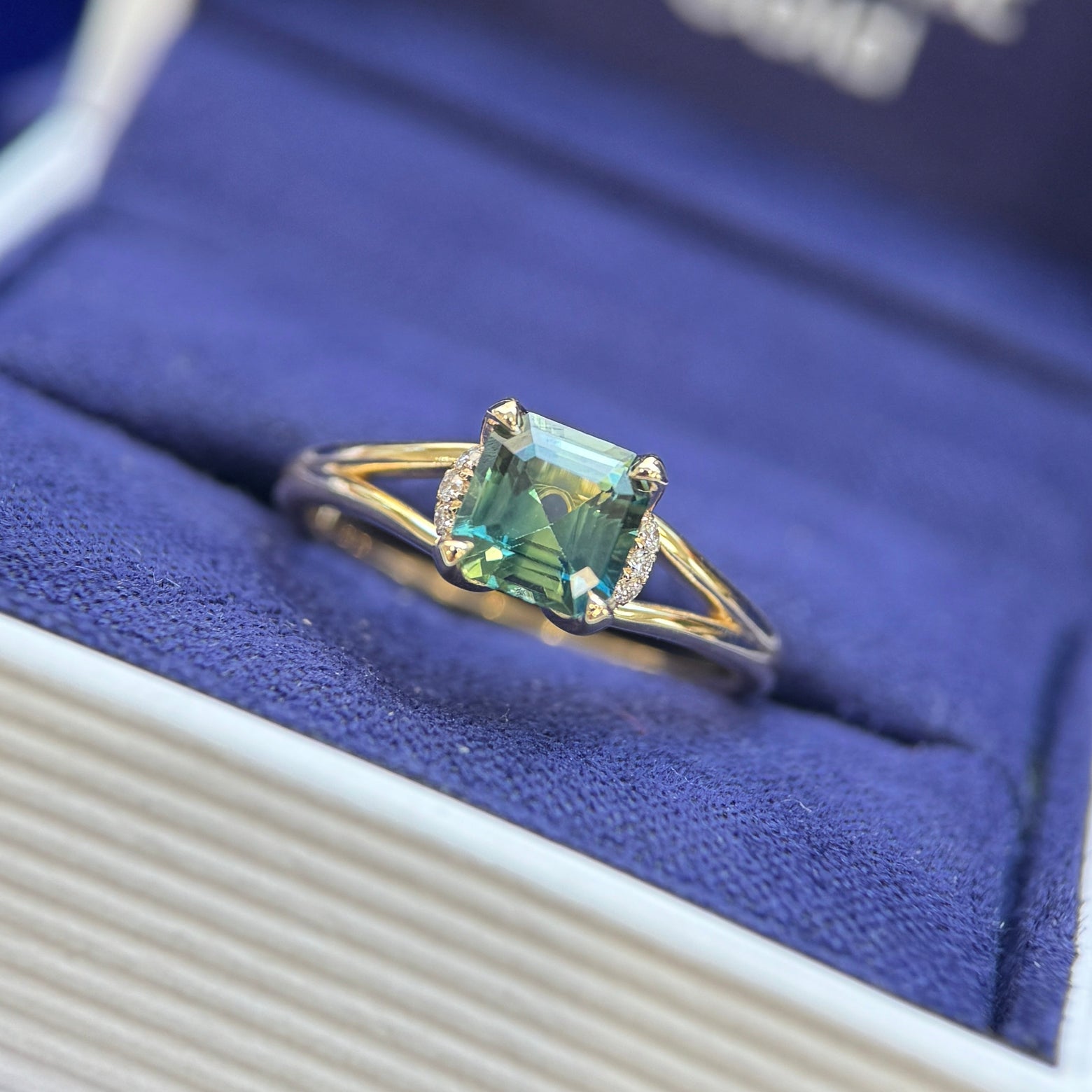 from view of 14k yellow gold and 1.08ct Asscher Teal Sapphire with 6 clear diamonds on tapered band custom ring size 5.25