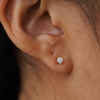 Close up view of a model's ear wearing a yellow gold Diamond Flat Back Earring