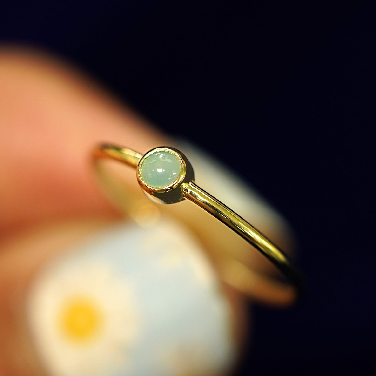A model holding a Jade Ring tilted to show the bezel setting