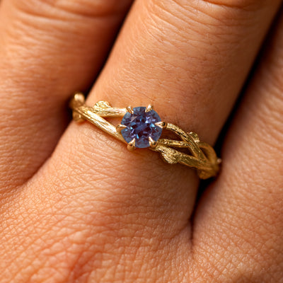 Close up view of a model's fingers wearing a 14k yellow gold Lab Alexandrite Branches Ring
