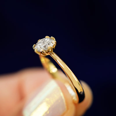 A model holding a Diamond Petal Ring tilted to show the side of the ring