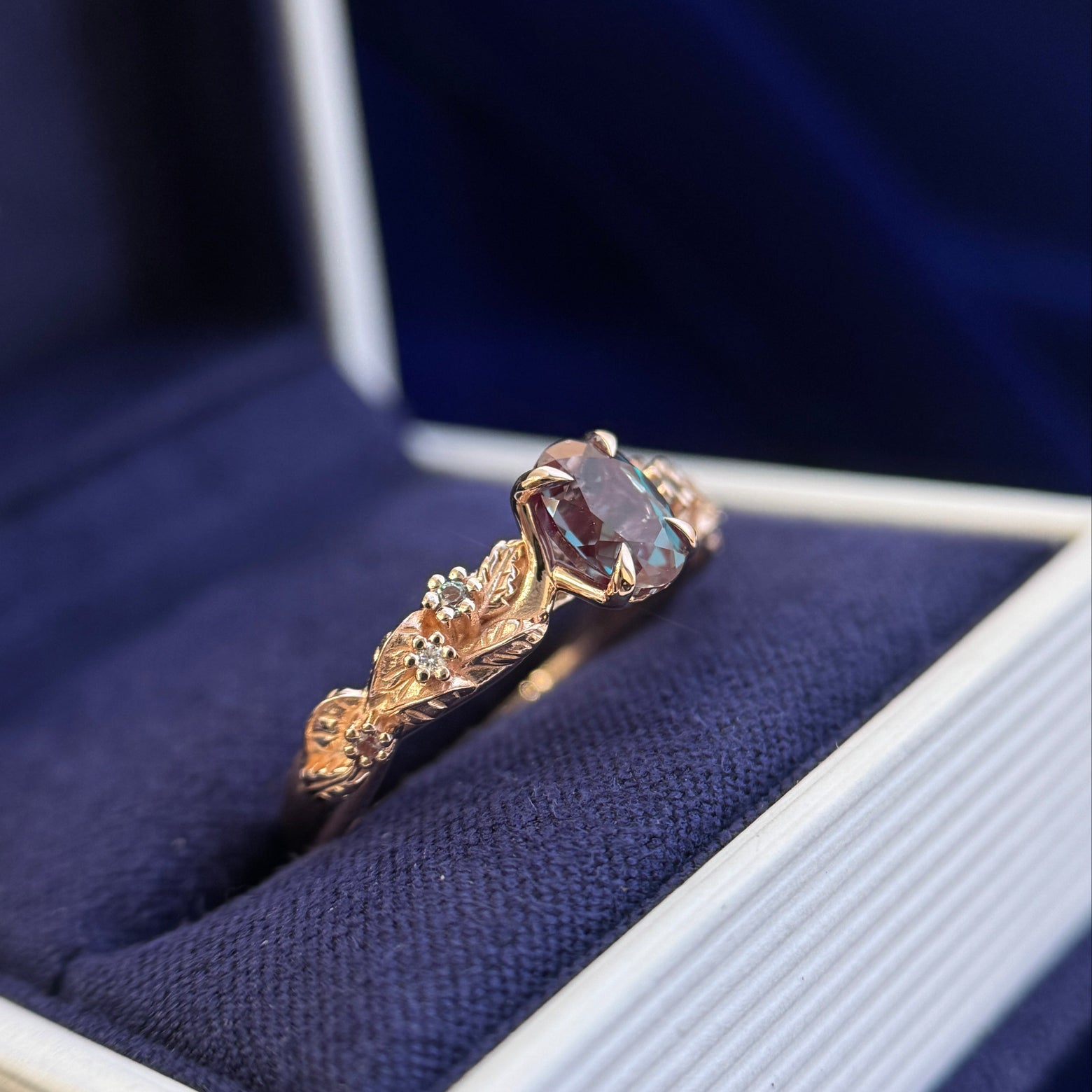 side view of 14k Rose Gold and 1ct 5x7mm Oval Alexandrite with a Cluster of Round Moissanites and Alexandrites on Leaves and Vines Custom Ring, size 7.75