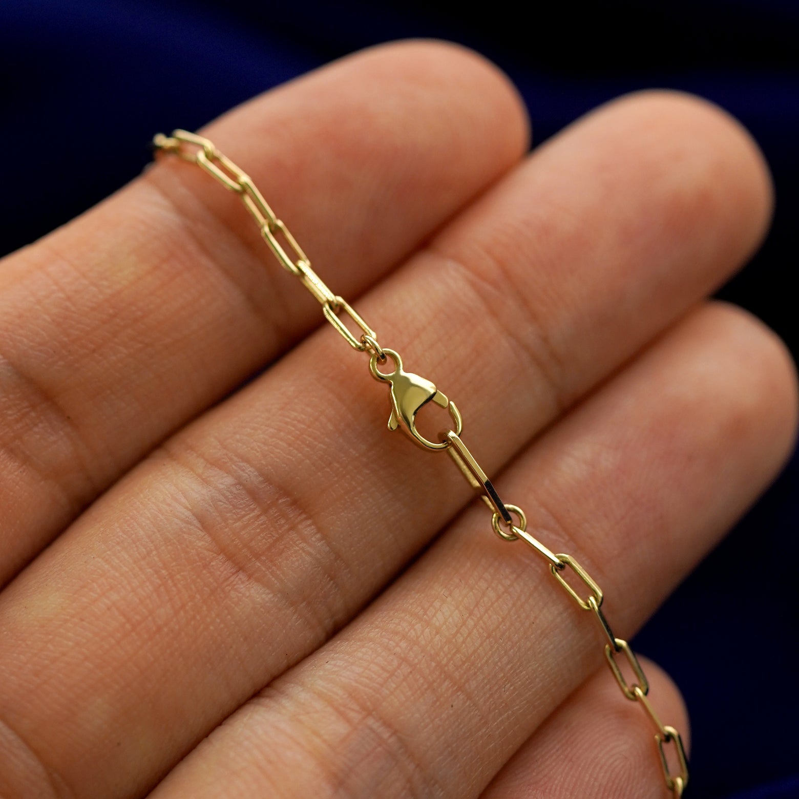 A model holding a lock necklace to show the lobster claw clasp on the butch chain