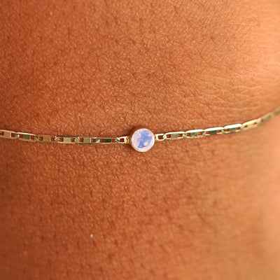 Close up view of a models wrist wearing 14k yellow gold Moonstone Bracelet