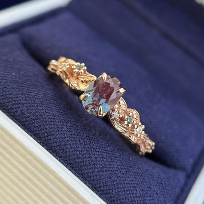 front view of x4k Rose Gold and 1ct 5x7mm Oval Alexandrite with a Cluster of Round Moissanites and Alexandrites on Leaves and Vines Custom Ring, size 7.75