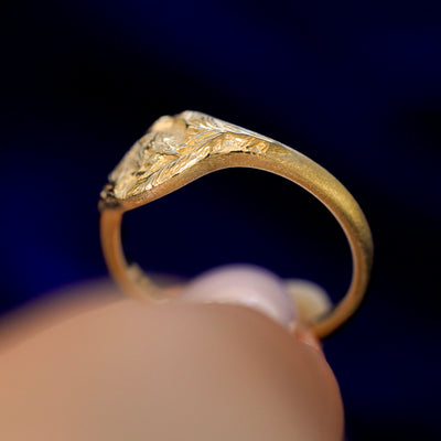 A model holding a Pine and Bird Ring tilted to show the thickness of the ring