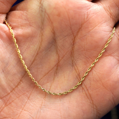 A yellow gold Rope Anklet draped on a model's palm