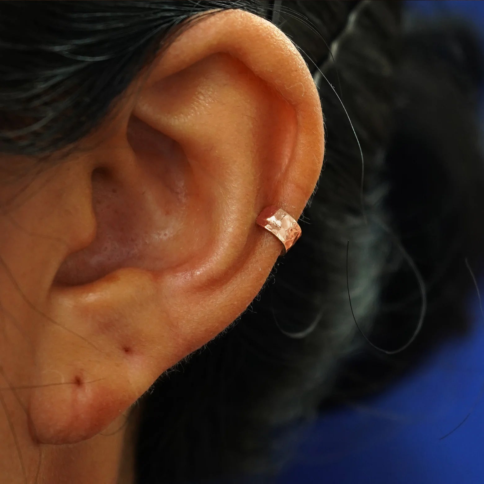A model's ear wearing a 14k rose gold Hammered Thick Cuff