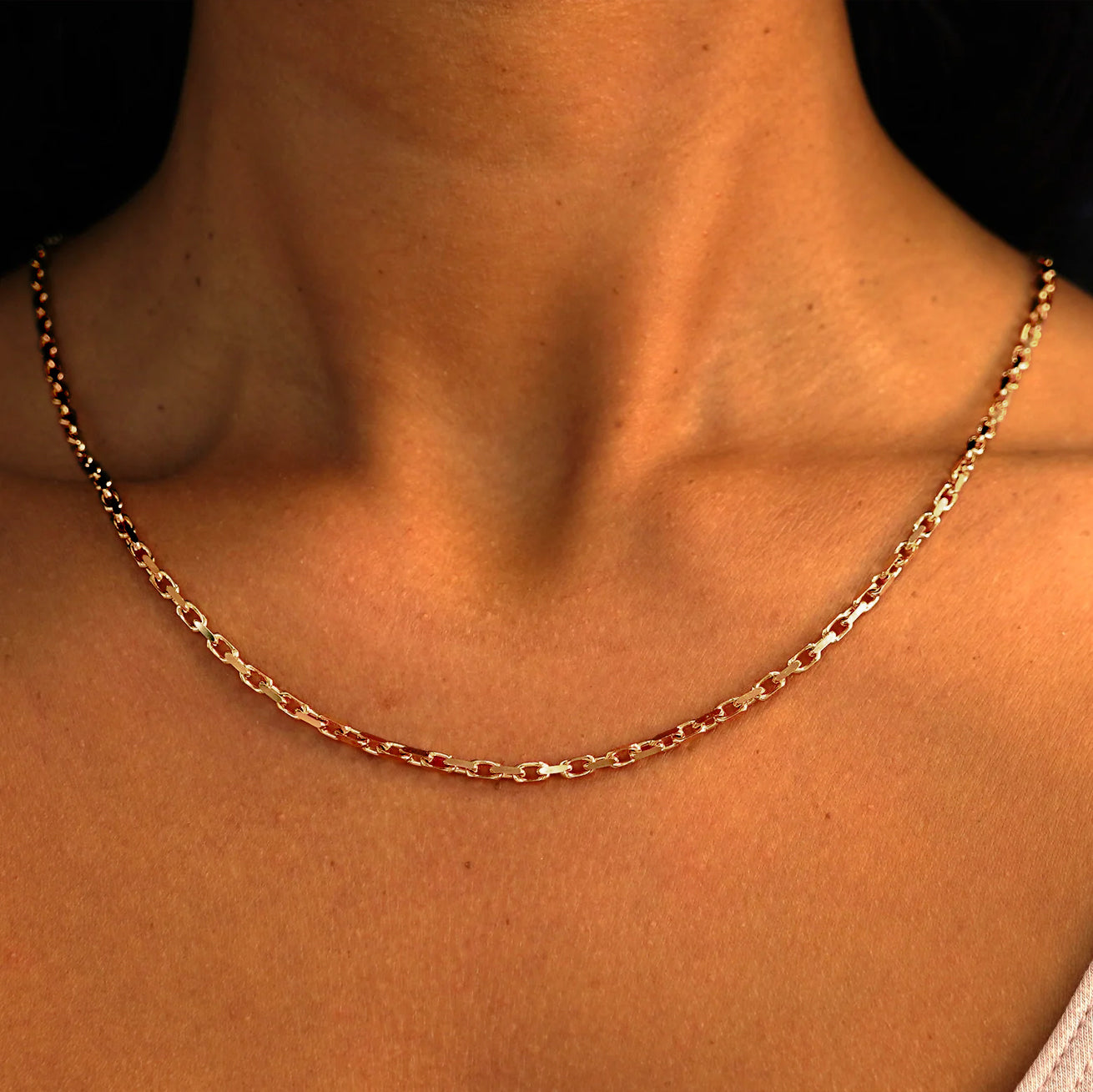 Close up view of a model's neck wearing a solid 14k rose gold Anchor Chain