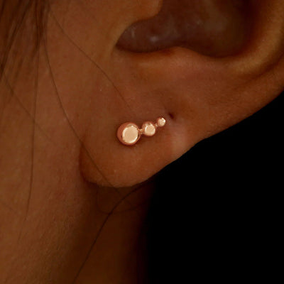 A model's ear wearing a solid rose
gold Graduated Ball Earring