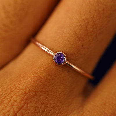 Close up view of a model's hand wearing a 14k rose gold Amethyst Ring