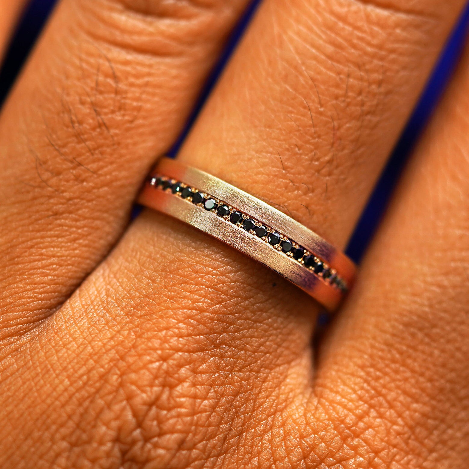 Close up view of a model's fingers wearing a 14k rose gold Endless Diamond Band
