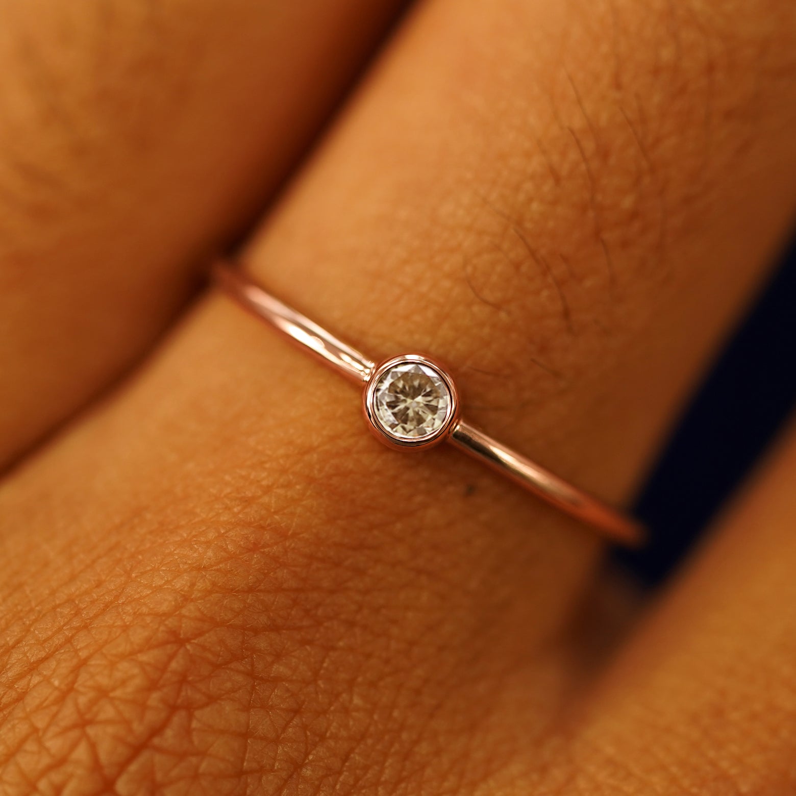 Close up view of a model's fingers wearing a 14k rose gold Champagne Diamond Ring