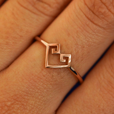Close up view of a model's fingers wearing a 14k rose gold Chere Heart Ring