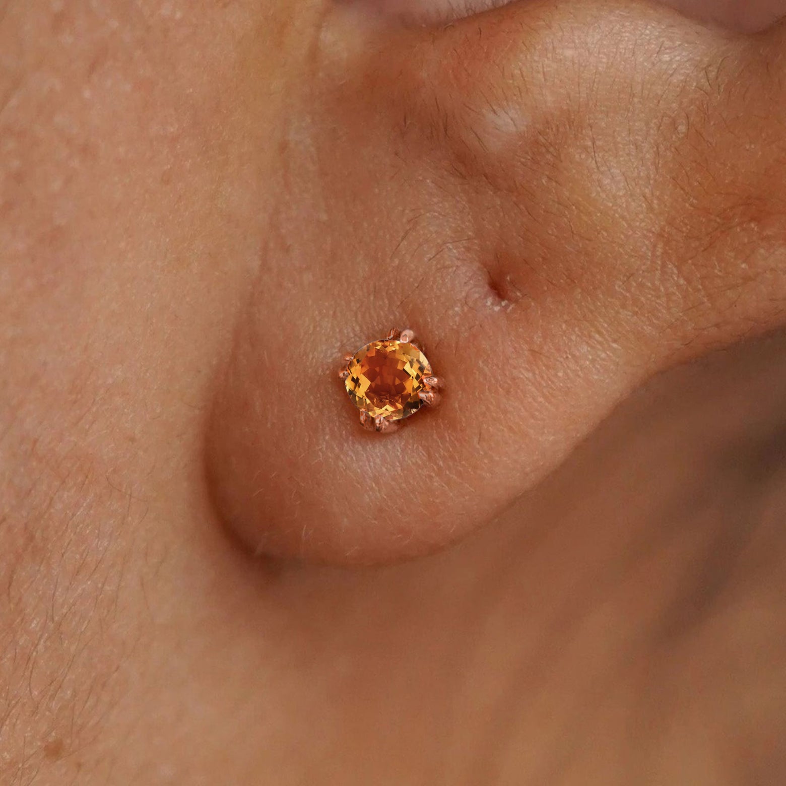 Close up view of a model's ear wearing a 14k rose gold Citrine Stud Earring