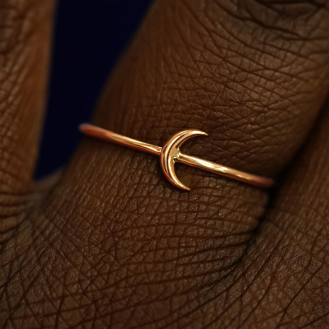 Close up view of a model's fingers wearing a 14k rose gold Moon Ring