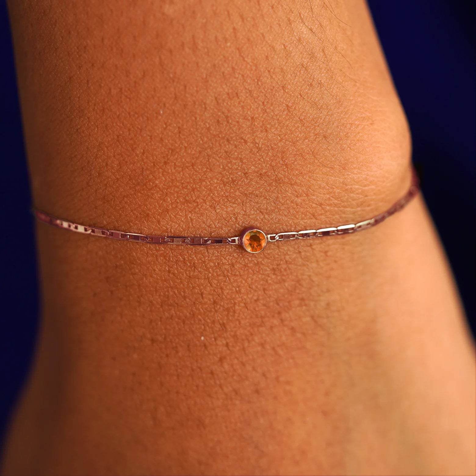 A model's wrist wearing a 14 karat rose gold Fire Opal Bracelet