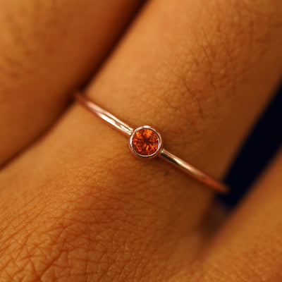 Close up view of a model's fingers wearing a 14k rose gold Fire Opal Ring
