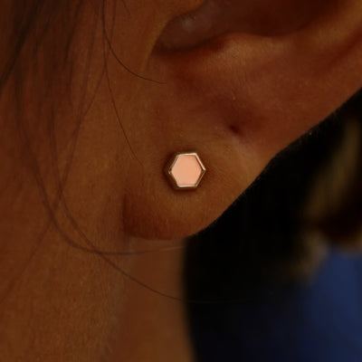 Close up view of a model's ear wearing a rose gold Hexagon Earring