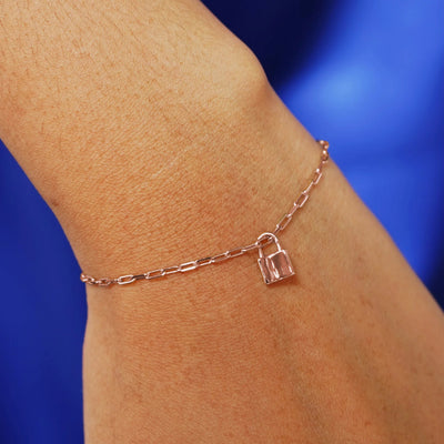 Close up view of a model's wrist wearing a rose gold Lock Charm on a Butch Bracelet