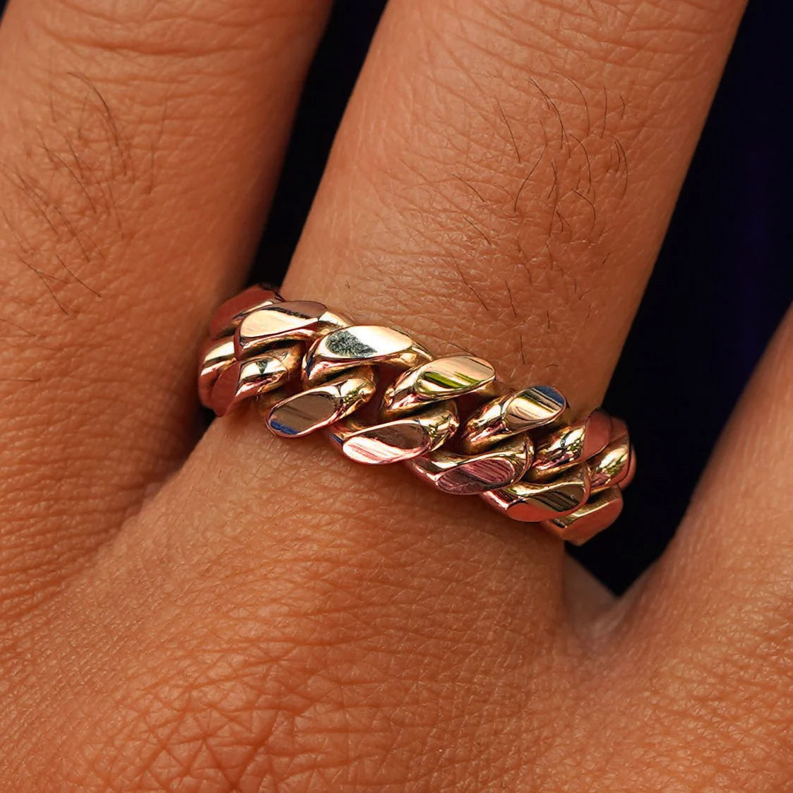 Close up view of a model's hand wearing a rose gold Miami Cuban Ring