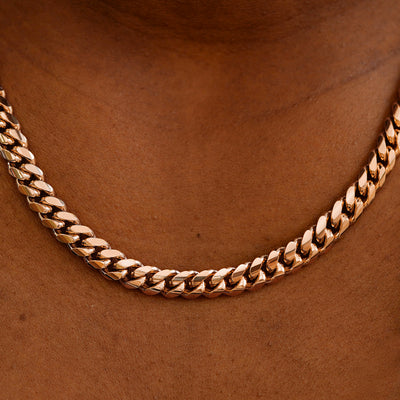 Close up view of a model's neck wearing a rose gold Miami Cuban Chain