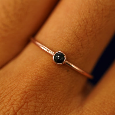 Close up view of a model's fingers wearing a 14k rose gold Onyx Ring