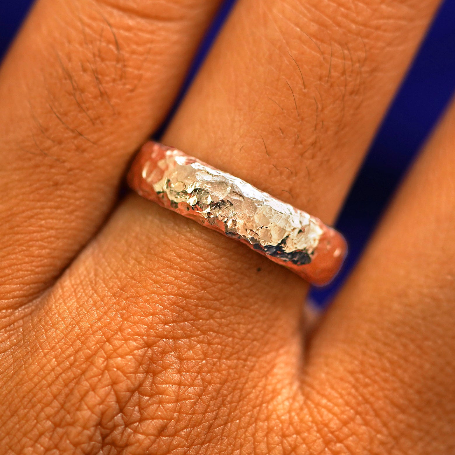 Close up view of a model's fingers wearing a 14k rose gold Organic Band