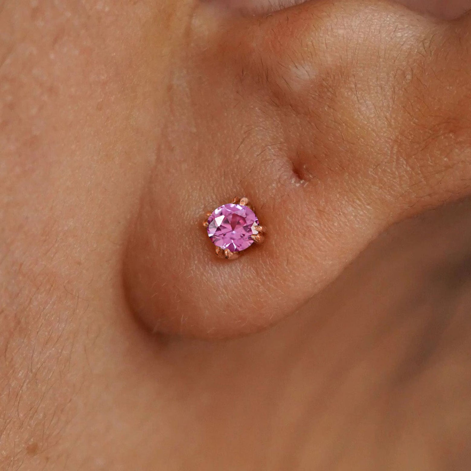 Close up view of a model's ear wearing a 14k rose gold Onyx Earring