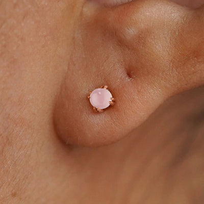 Close up view of a model's ear wearing a 14k rose gold Rose Quartz Earring
