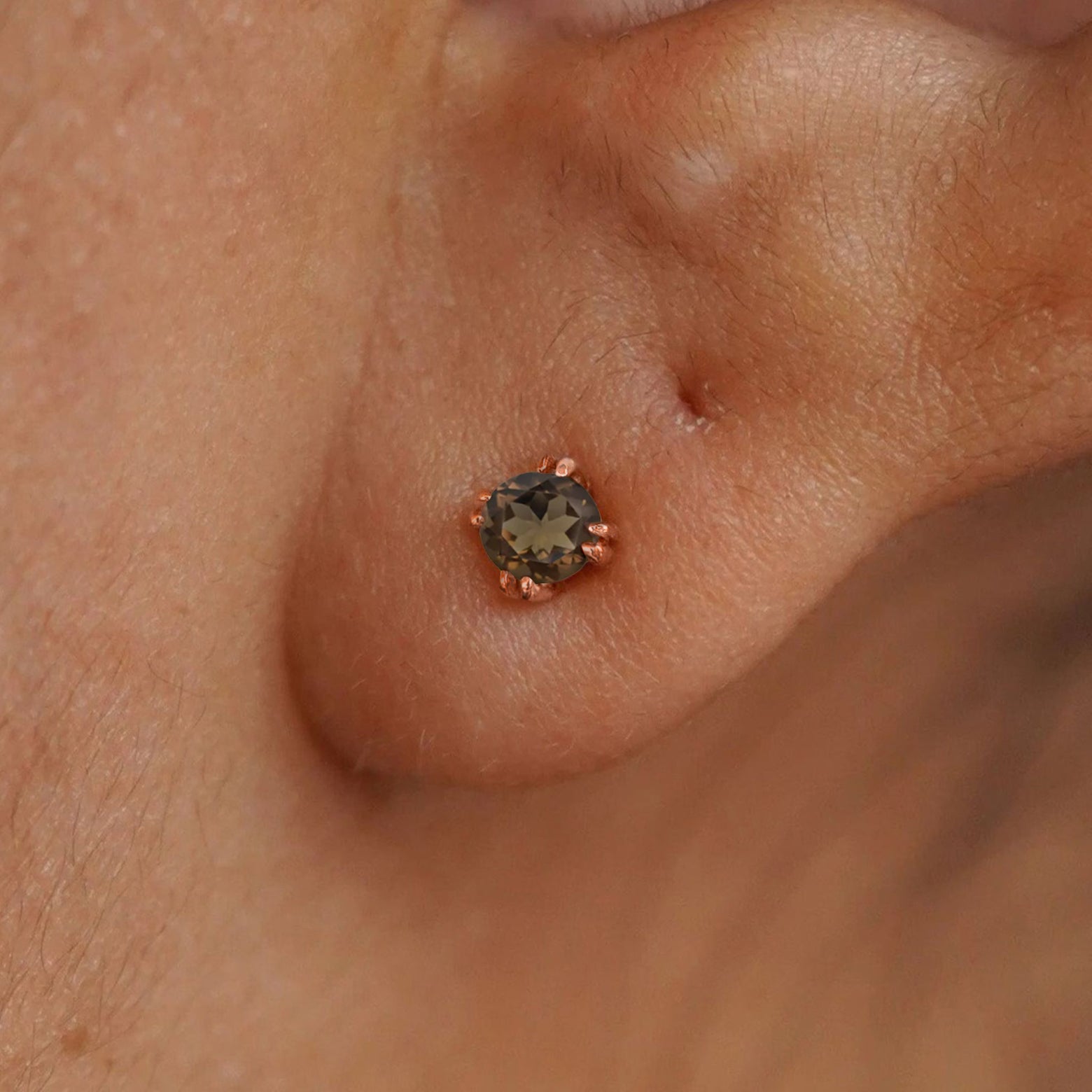 Close up view of a model's ear wearing a 14k rose gold Rose Quartz Earring