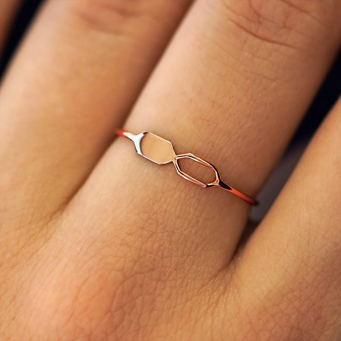 Close up view of a model's fingers wearing a 14k rose gold Tanlah Ring