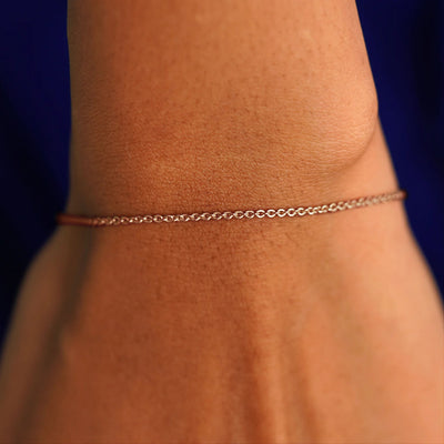 A model's wrist wearing a solid rose gold Thick Cable Bracelet