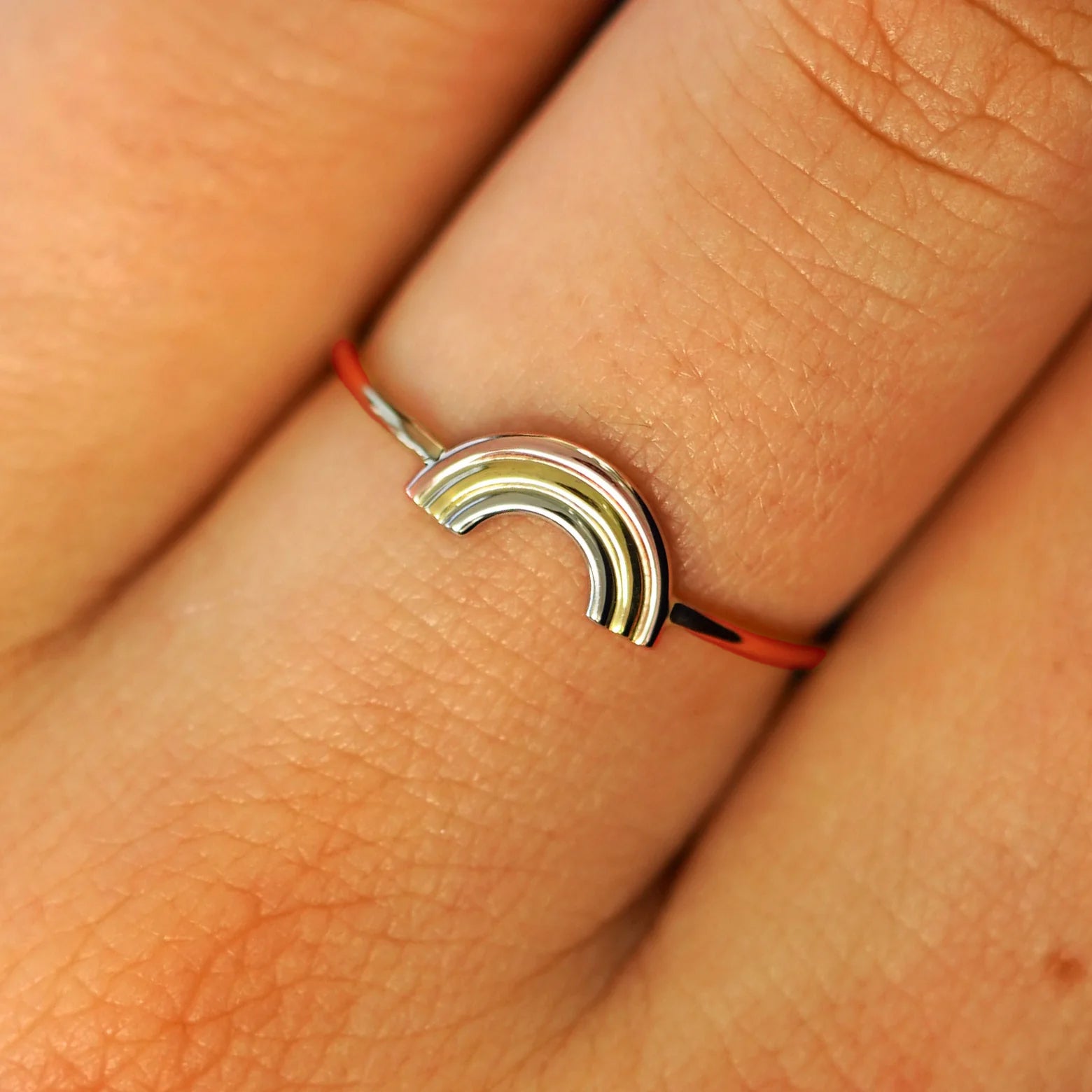 Close up view of a model's fingers wearing a solid rosegold Rainbow Ring