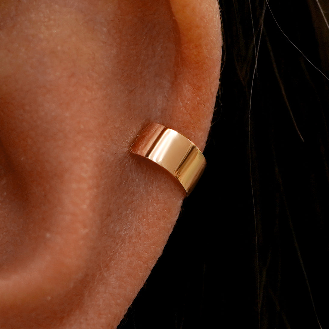 Close up view of a model's ear wearing a rose gold Wide Cuff