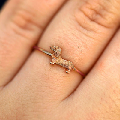 Close up view of a model's fingers wearing a 14k rose gold Dog Ring