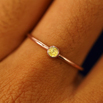 Close up view of a model's fingers wearing a 14k rose gold Yellow Diamond Ring