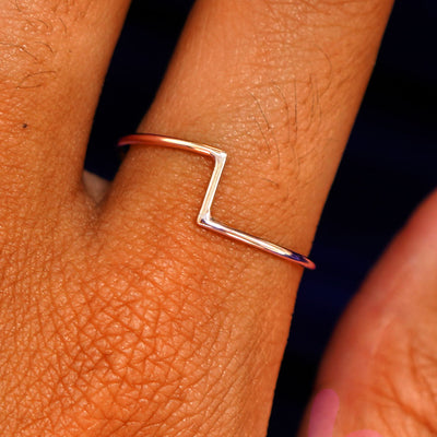 Close up view of a model's fingers wearing a 14k rose gold Zig Zag Ring