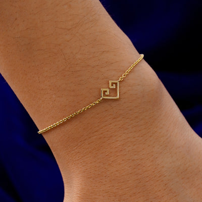 A model's wrist wearing a 14k solid gold Chere Heart Bracelet