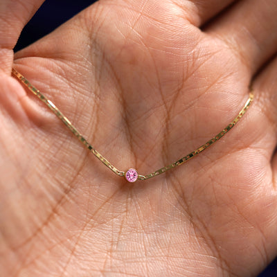 A yellow gold Pink Sapphire Bracelet draped on a model's palm