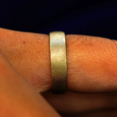 Side view of a 14 karat solid gold Mix Stardust Band on a model's finger