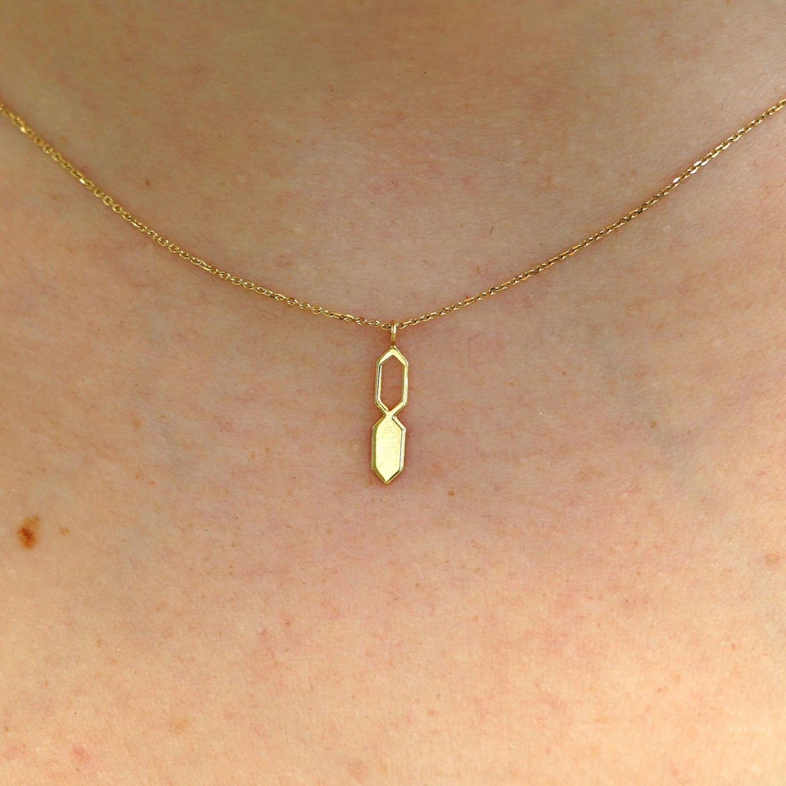 Close up view of a model's neck wearing a yellow gold Tanlah Cable Necklace
