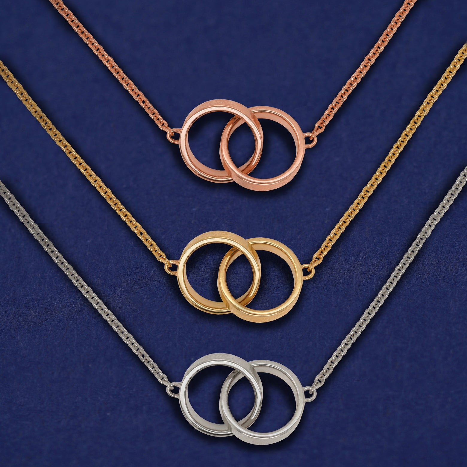 Three versions of the Bound Together Necklace shown in options of rose, yellow, and white gold