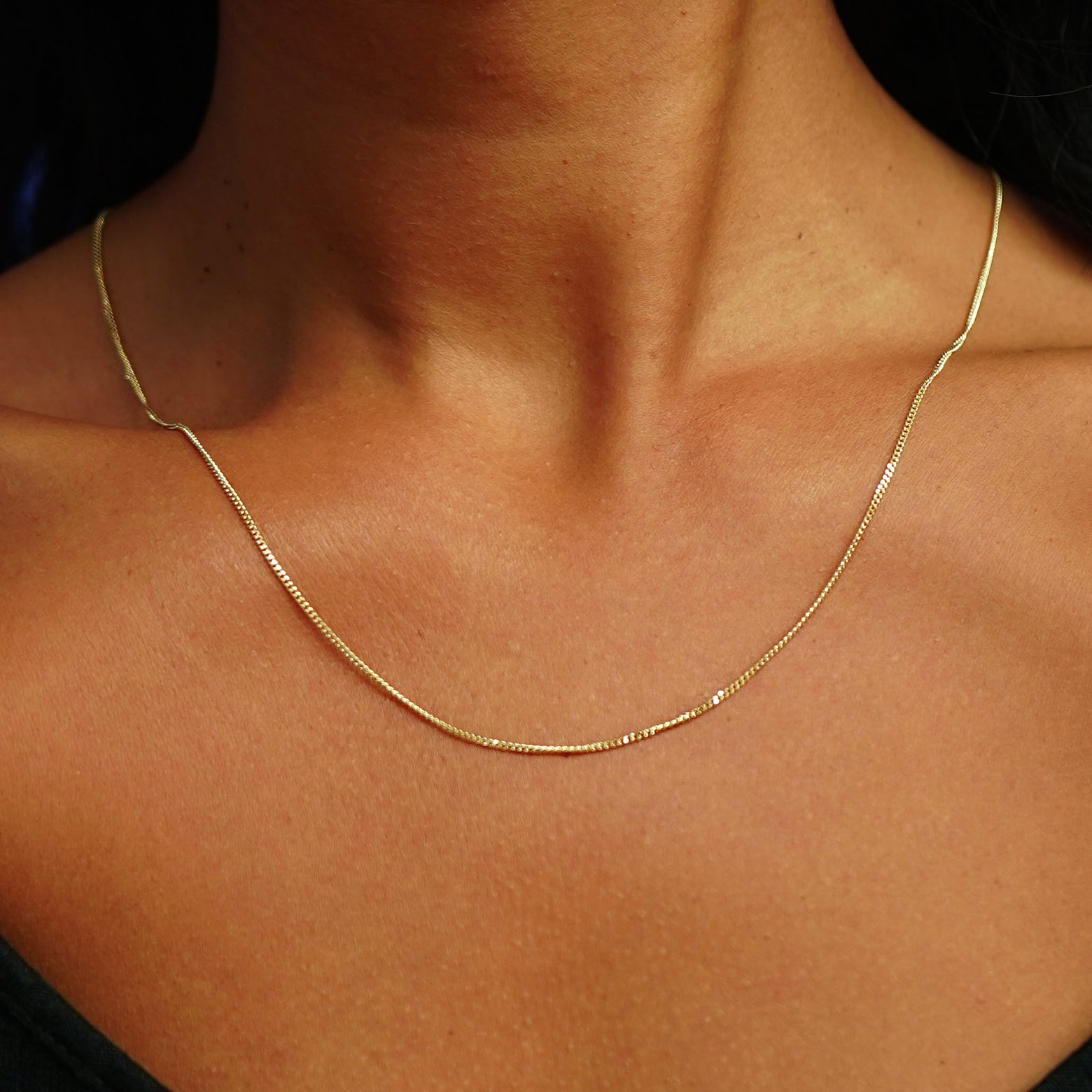 Close up view of a model's neck wearing a longer Mini Miami Chain