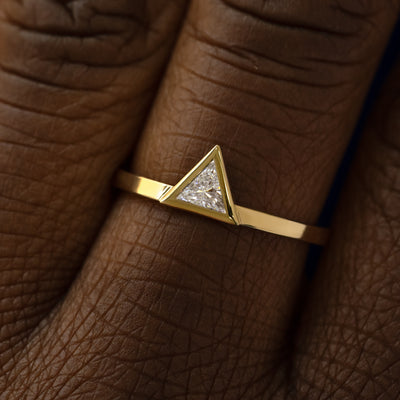 Close up view of a model's hand wearing a 14k yellow gold Triangle Clear Diamond Ring