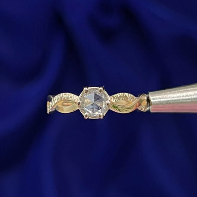 This 14k yellow gold band features a prongs-set rose-cut round salt and pepper diamond on a twisted-loop band with wooden-like texture