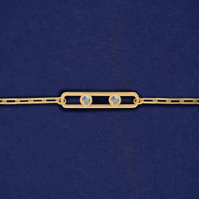A yellow gold elongated open oval link with two bezel set Opals inside on a 14k gold Butch chain bracelet