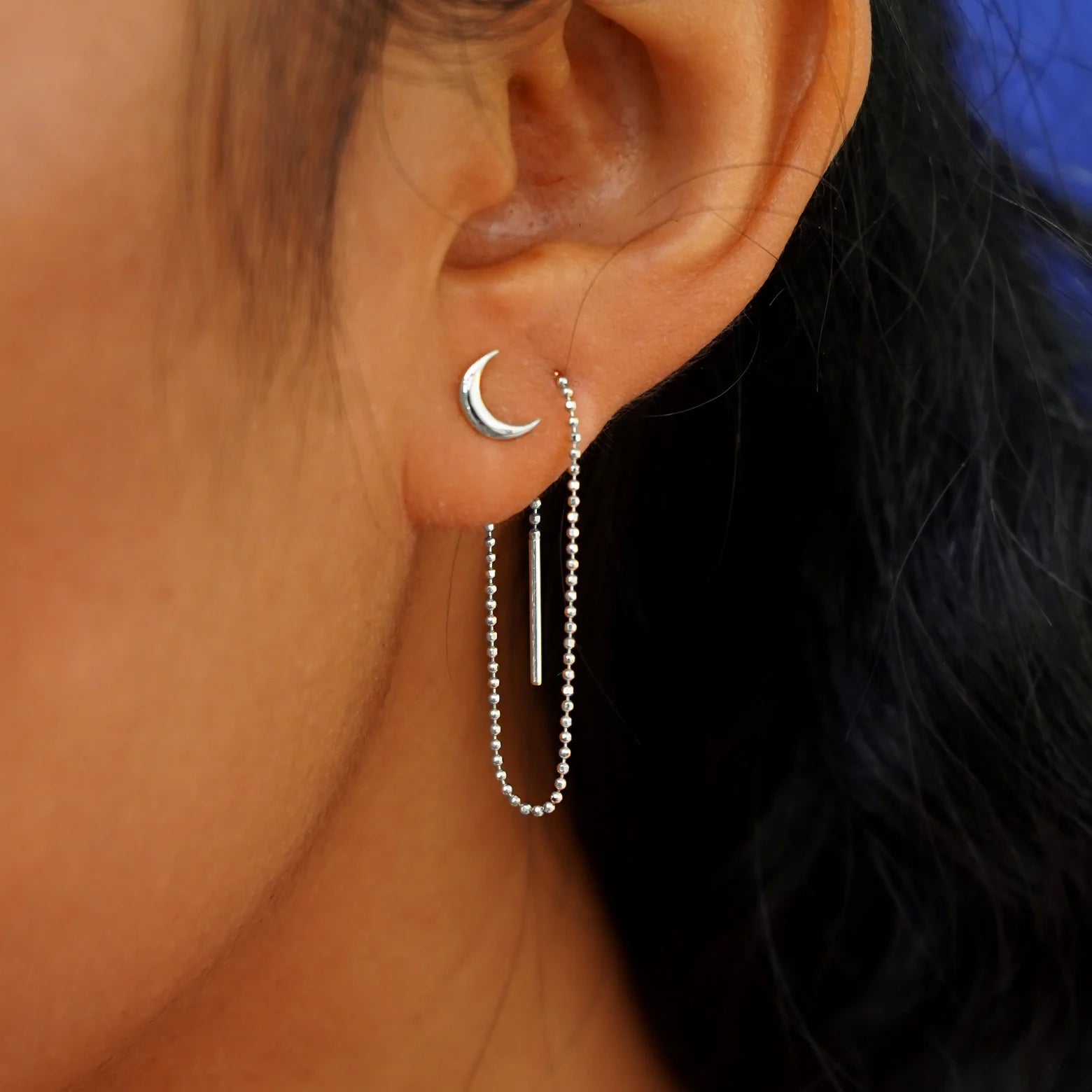 A model wearing a Moon Earring with a white gold Extender attached at the back and threaded through the front of a second piercing